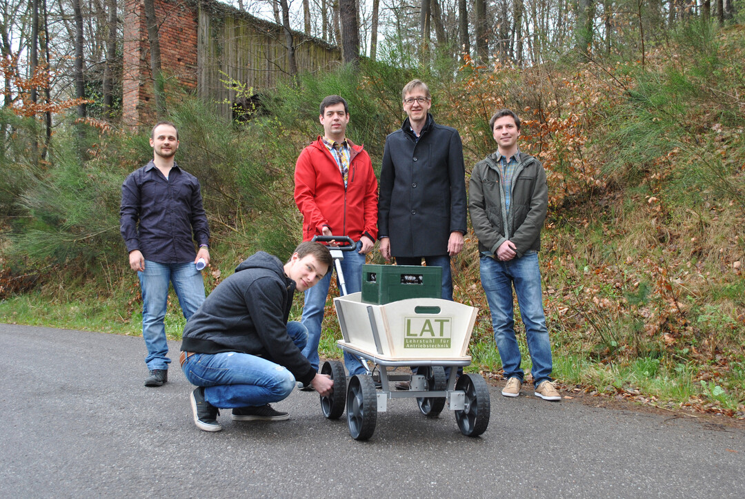 Keine vorzeitige Maitour, sondern Test des Prototypen: Die Studenten Sergej Fabich (l.) und Matthias Hoffmann (kniend) testen mit Prof. Matthias Nienhaus (2.v.r.) und seinen Mitarbeitern Nico Haser (M.) und Robert Schwartz (r.) den Bollerwagen.