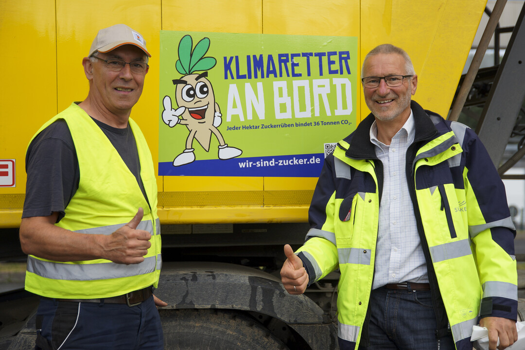 Nikolaus Zimmermann (links) und Ernst Merz aus der Rohstoffabteilung des Werkes Ochsenfurt der Südzucker AG vor dem neu angebrachten Aufkleber der „Aktion Rübenkampagne“